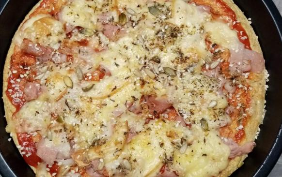 Vejce smíchat s moukami, 
olejem, prdopečem a pizza kořením dle uvážení a chuti,přidat asi decku vody, vyšlehat ručním šlehačem, kdyby bylo těsto stále tuhé přidat ještě vodu asi tolik aby těsto bylo řidší. Nalít do olejem vymazané zapékací formy potřít rajčatovým pyrém a péct v předehřáté troubě na 200 stupňů asi 10 min. Pak vyndat posypat šunkou nakrájenou na proužky, sýrem, já ještě posypala semínky slunečnicí, dýňová a seznam  nebo tím co kdo má rád, posypat ještě pizza kořením nebo jen oreganem a zase zapéct do zlatova.